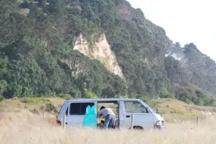 Kompakter Wohnmobil-Van an der Küste mit Ausblick auf Berge und Meer
