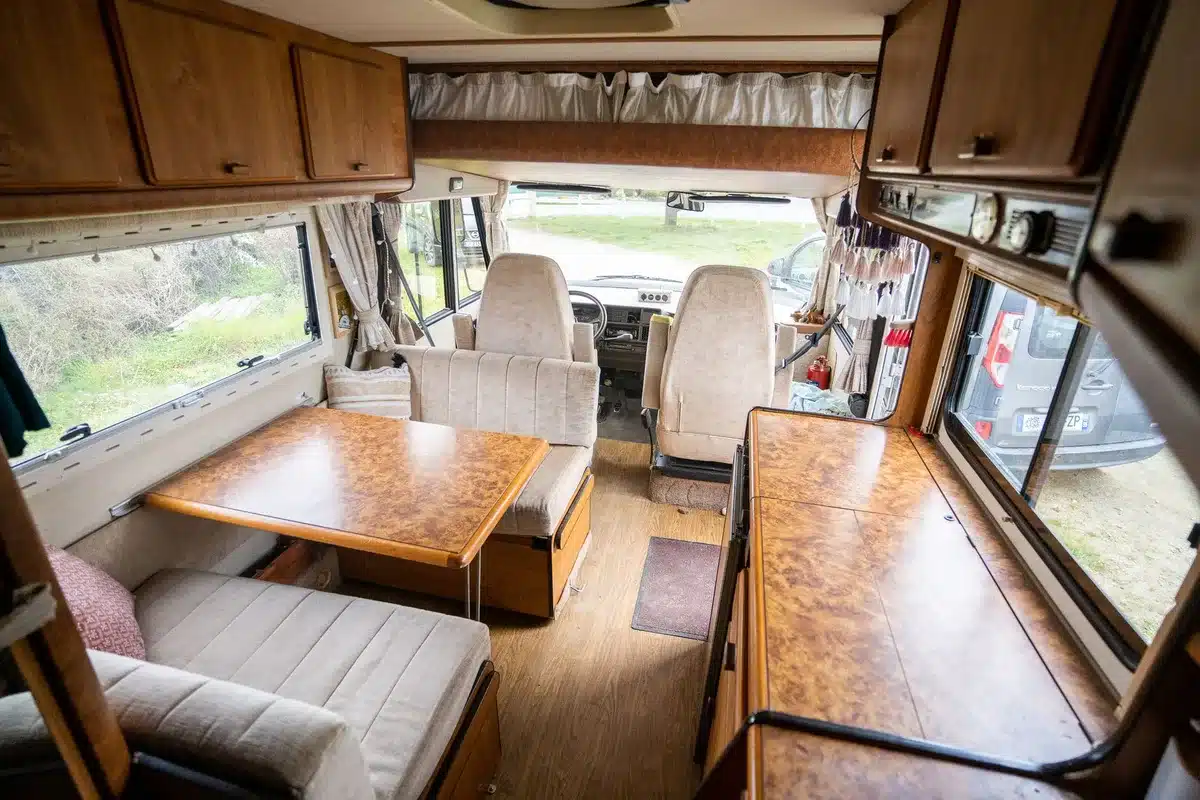 Moderner Teilintegrierter Wohnmobil-Innenraum mit offener Wohnküche und Hubbett
