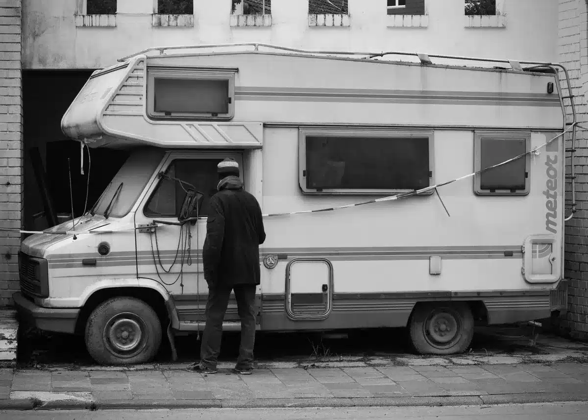 Ausstellungshalle mit mehreren Wohnmobilen und Caravans auf der Messe, Besucher zwischen den Fahrzeugen