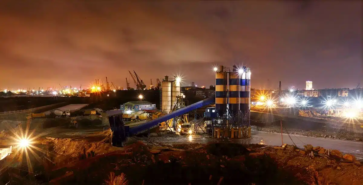 Baustelle eines modernen Industriewerks mit Kränen und Baumaschinen