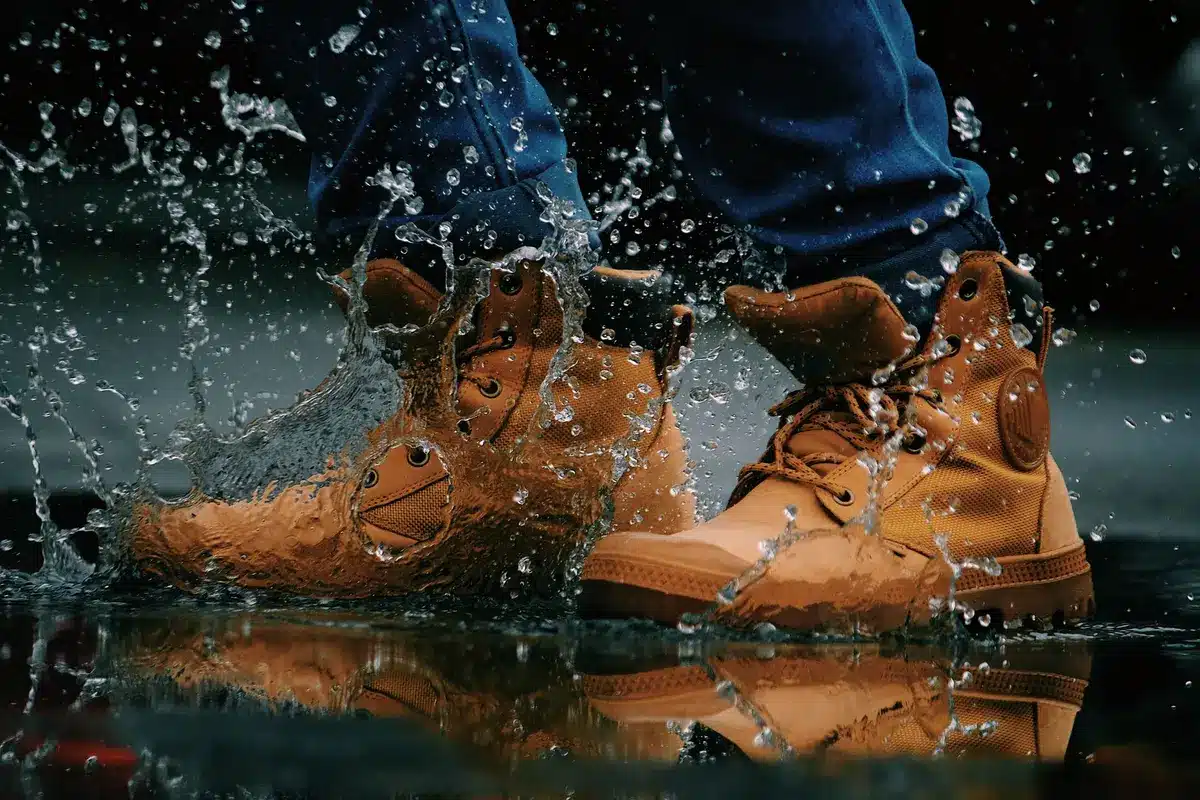 Motorradstiefel auf nasser Straße mit Wassertropfen, zeigt Wasserdichtigkeit