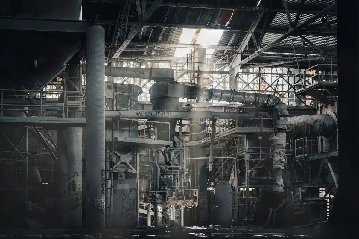 Absteigende Grafiklinie über einer Autofabrik mit Fertigungsausrüstung symbolisiert sinkende Nachfrage
