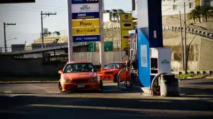 Auto an der Zapfsäule mit sichtbarem Preisschild an der Tankstelle