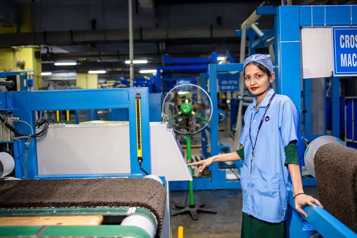 Industrielle Fertigungslinie mit Arbeitern an Montagearbeitsplätzen und teilweise bestückten Komponenten
