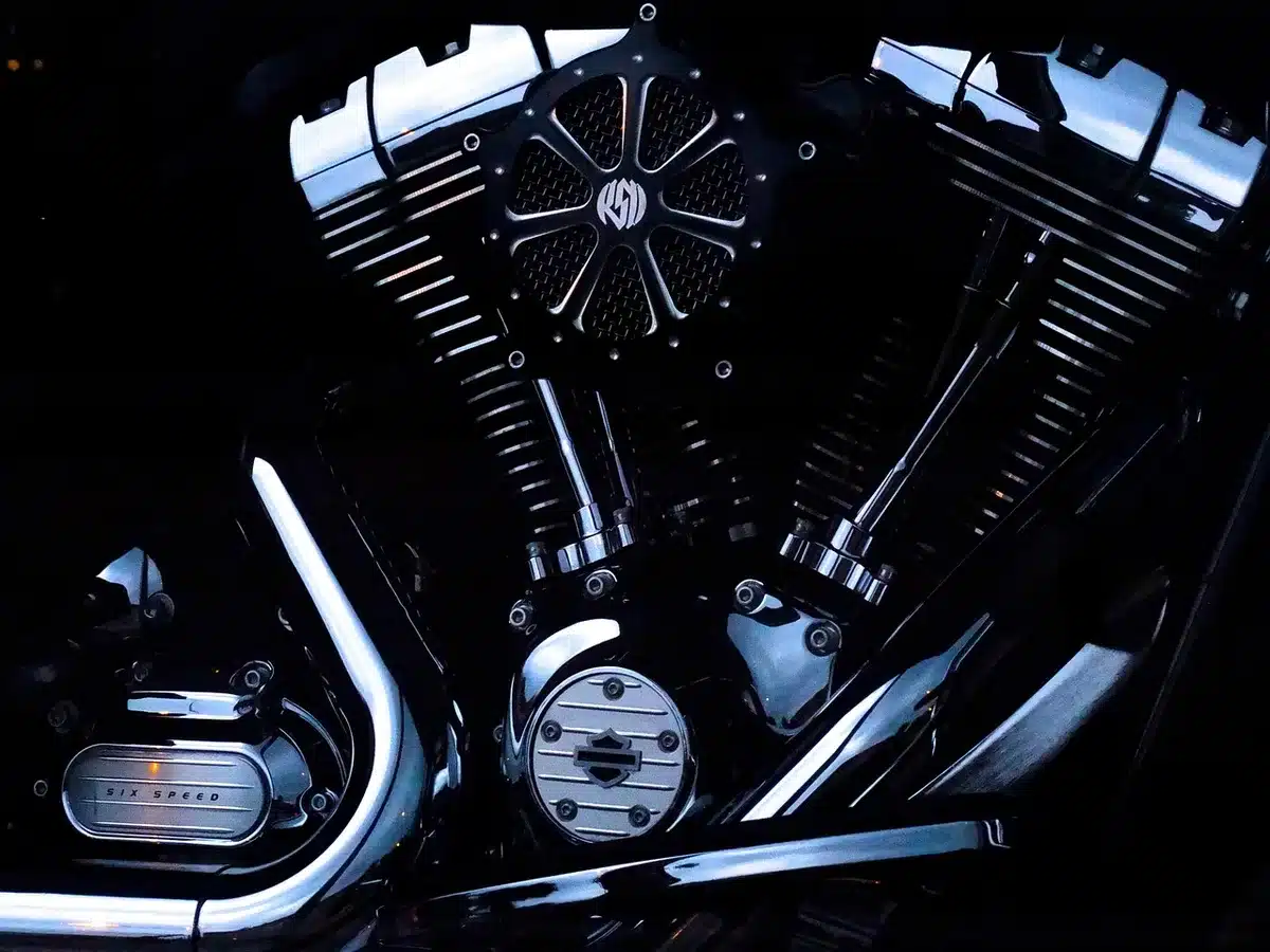 Blick in ein anonymes Motorradmontagewerk mit Rahmen und silhouettenhaften Arbeitern