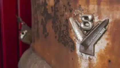 Werkstatt mit Coupé-Karosserie auf Hebebühne und freigelegtem V8-Motor