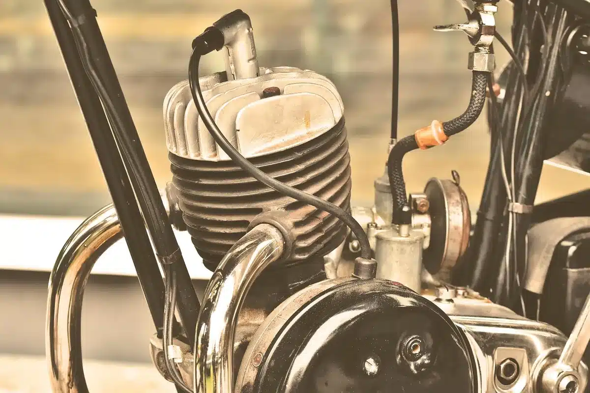 Aufgeschnittener Einzylinder-Zweitaktmotor neben technischen Komponenten