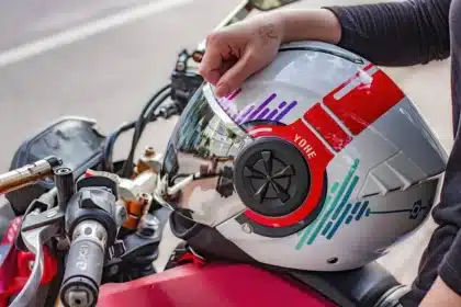 Anonymer Textil‑Motorradanzug mit Helm und Stiefeln in einer Garage