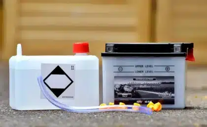 Mobile 12‑V-Kühlbox im Heckbereich eines anonymen Campervans neben Rucksack und Picknickdecke
