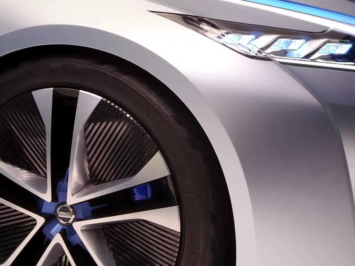 Zwei Elektroautos nebeneinander mit Preisschildern in einem neutralen Showroom