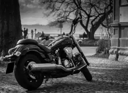 Silhouette von Motorradbike-Lenker und Tank bei Dämmerlicht auf einem Parkplatz