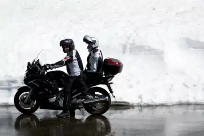Touring-Motorrad auf Bergpass mit Gepäck und kurvenreicher Straße im Hintergrund