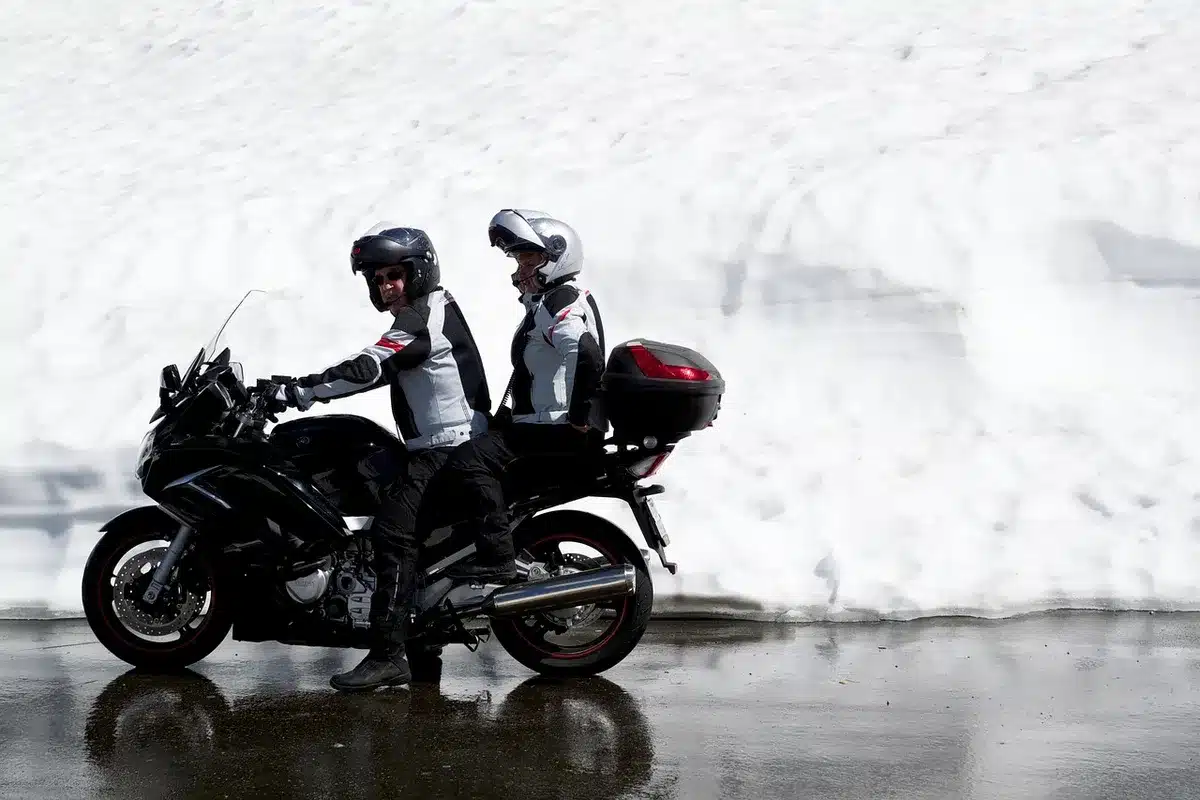 Touring-Motorrad auf Bergpass mit Gepäck und kurvenreicher Straße im Hintergrund