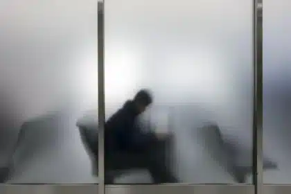 Silhouetten von Reisenden in einem Flughafenterminal vor Sicherheitsabsperrungen